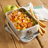 Vegetable salad with sweetcorn, radishes and cheese in a lunch box