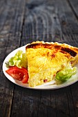 A slice of cheese quiche with salad garnish