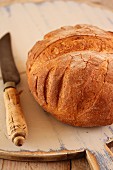 Rustic bread with a knife on a wooden board