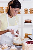 Woman decorating cake at bakery