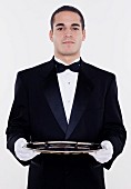 Portrait of male waiter holding tray