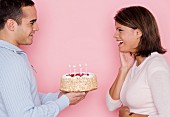 Profile of man holding cake and looking at woman