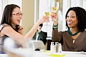 Two businesswomen toasting in restaurant