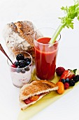 Frühstück mit Bloody Mary, Sandwich, Joghurt & Obst
