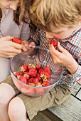 Boy and girl eating strawberry