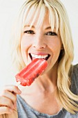 A young woman eating an ice lolly