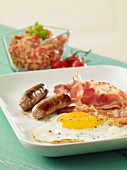 Englisches Frühstück mit Bratwürstchen, Spiegelei und Bacon