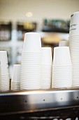 A stacked of disposable coffee cups in a cafe