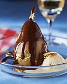 Pear in chocolate sauce with gold leaf and vanilla ice cream