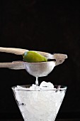 Lime being squeezed over ice