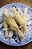 Wrapped corn tamales on plate