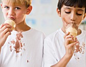 Zwei Jungen mit Eistüte & bekleckerten T-Shirts
