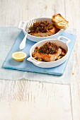 Salmon fillet with a crispy topping made from dried tomatoes, parsley and breadcrumbs, with olives and toast