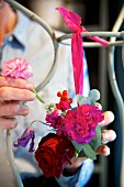 Frauenhände beim Herstellen einer Blumendekoration mit Steckschaumkugel