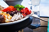 Meze-Platte mit Sardellen, Brokkoli, Tomaten, Paprika, Kartoffelsalat, Frikadellen, Oliven und Ouzo (Griechenland)