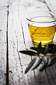 Olive oil and an olive twig on a wooden surface