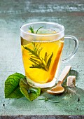 Orange tea with rosemary in a glass cup