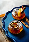 Two 'Old Fashioned' cocktails with cinnamon sticks and orange peel