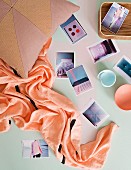 Postkarten, Becher und Tuch auf pastellfarbenem Untergrund arrangiert