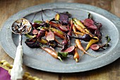 Roasted root vegetables on a plate with a spoon