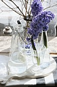 Blue hyacinths in glass vase on white wooden board on rustic table