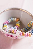 Colourful candy necklace in a mug