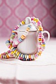 Colourful candy bracelets hanging on a milk jug