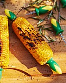 Grilled corn cobs on a sunny wooden table