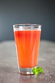 A cocktail made out of fresh vegetable and fruit juice (carrots, orange and beetroot)