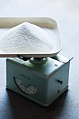 A pile of sugar on a old kitchen scale