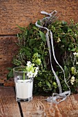 Christmas wreath of mistletoe and Star-of-Bethlehem flowers and sprig of Star-of-Bethlehem in glass of milk