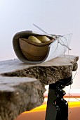 Stylised hunters' meal - wooden bowl of potatoes wrapped in felt mat on improvised, live-edge wooden table