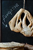 Fougasse hängt vor einer Tafel mit Kreideschrift