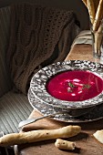 A bowl of beetrot soup with sour cream, dill and bread.