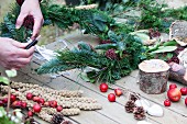 Hand-crafting a winter wreath with bird feeders