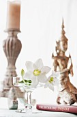White lilies, candlestick and Oriental statue decorating table