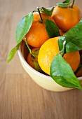 Tangerines with leaves in a bowl