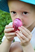 A little boy holding a chocolate Easter egg