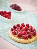 Himbeertörtchen und frische Himbeeren