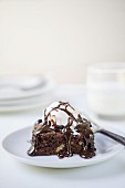 A brownie with ice cream and chocolate sauce