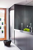 Elegant black and grey fitted kitchen with black granite worksurface and mirrored splashback