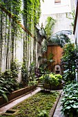 Dschungelartig begrünter, schmaler Innenhof in Buenos Aires