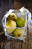 Pears in a plastic box wooden surface
