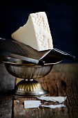 Pecorino Romano cheese on a grater in a metal bowl