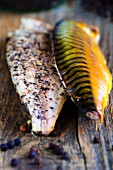 Smoked mackerel fillets with pepper on a pine wood board