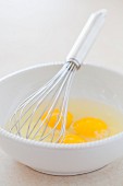 Beaten eggs in a bowl with a whisk