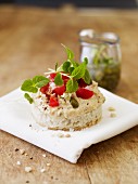 White bread topped with hummus, capers and tomatoes