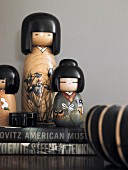 Various, painted wooden Kokeshi dolls on stacked books