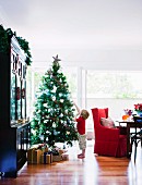 Little boy gazing at star on Christmas tree