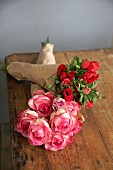 Two bouquets wrapped in paper lying on wooden table